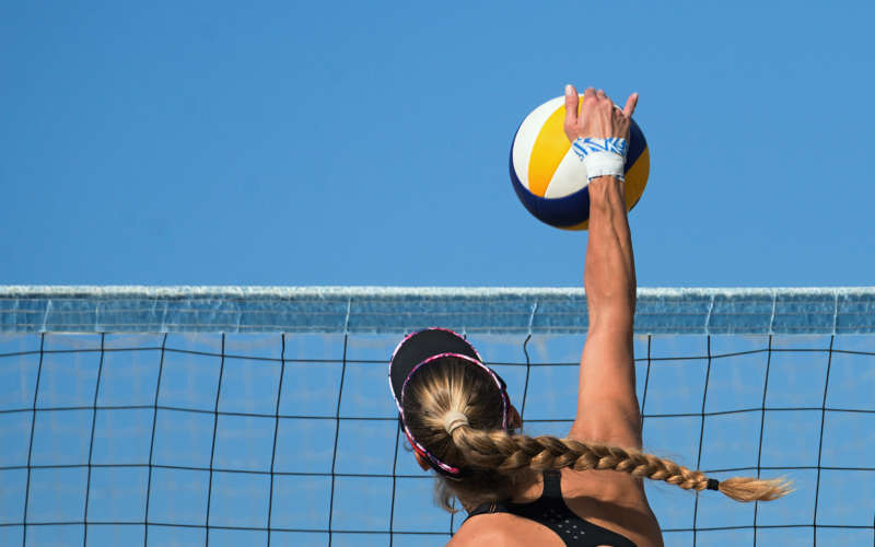 Female athletes playing beach volleyball